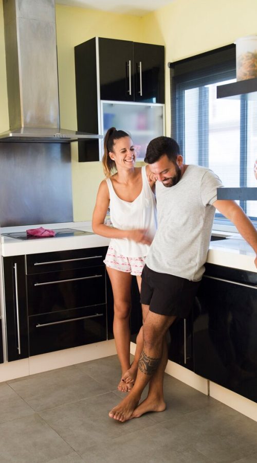 happy-couple-standing-modern-kitchen_23-2147892044